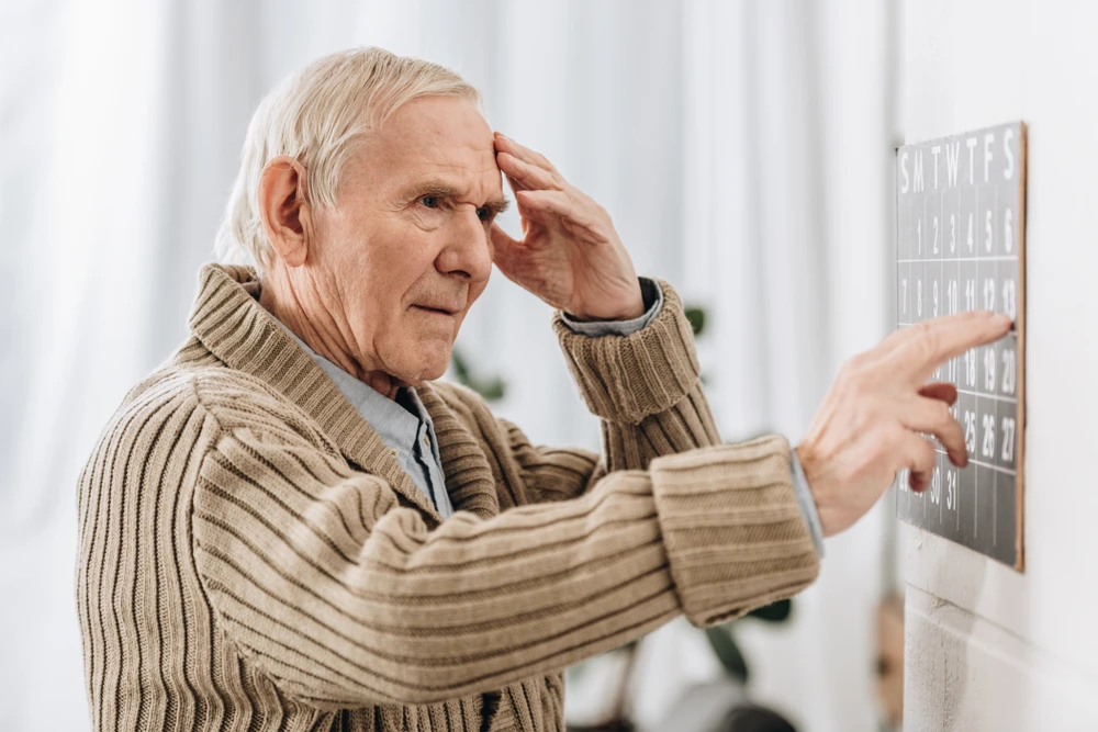 elderly man looking confused at calendar memory loss