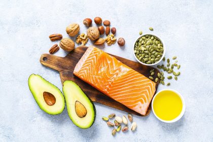 Heart-healthy foods including salmon, avocado, nuts and olive oil to lower cholesterol naturally
