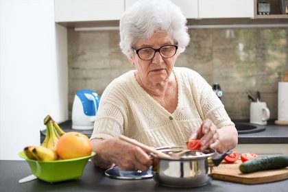 Elderly woman cooking safely in a senior-friendly kitchen