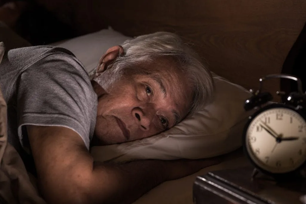 Senior man awake at night struggling with insomnia