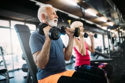 senior man and woman lifting dumbbells for strength training over 70