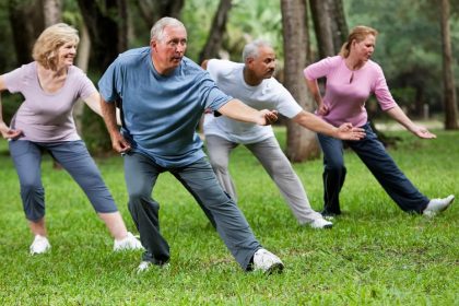 Group of seniors doing tai chi outdoors in a park - tai chi benefits for balance